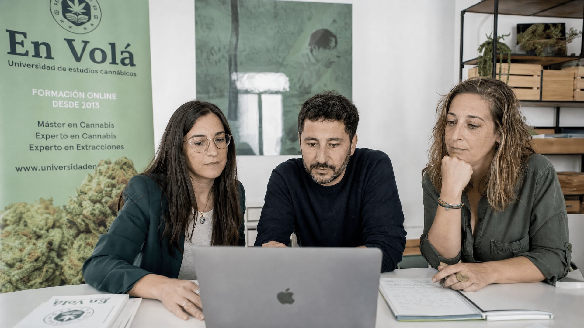 En Volá educators reviewing three online cannabis course scripts beside a laptop